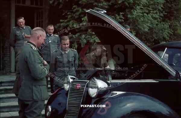 Dutch officer repairs staff car infront of german staff officers Holland 1940