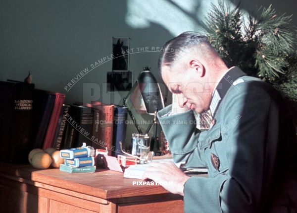 German army officer reading book. Rolls of German agfacolor film sitting on his table. Munich Germany 1942