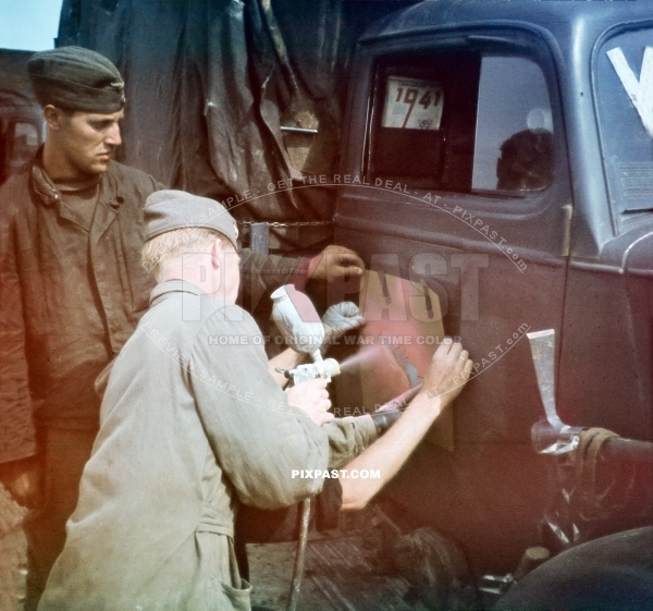 German Luftwaffe ground crew spray painting unit symbol on the door of a Opel army truck. Romania 1941