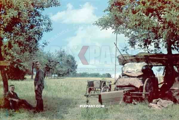 German soldiers resting beside horse drawn wagon in French orchard 1940