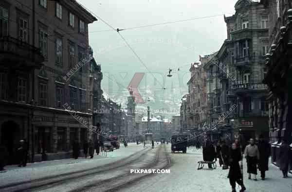Innsbruck, Austria, 1939, Winter Snow, Maria Theresien Strasse, cars, trucks and bus, Alps in the background. 