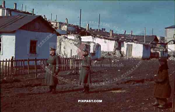 Mariupol Ukraine 1942 German army officers in destroyed town with Russian peasant child.