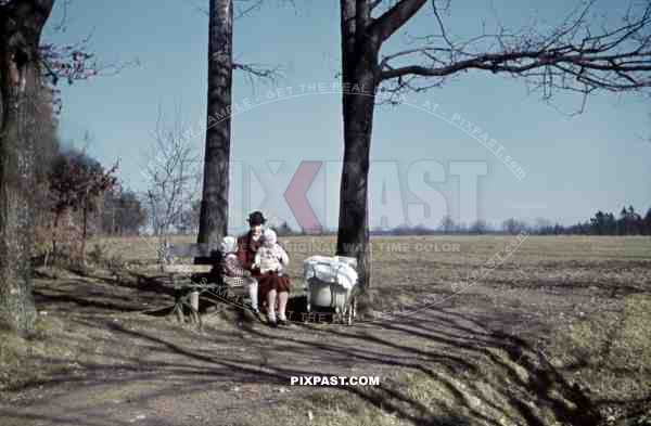 mother sitting on a bench with her two children, Germany 1938
