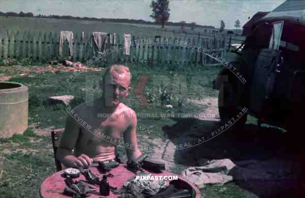 Russia summer 1941, 4th Panzer Division. Repairing staff car and cleaning Luger pistols.