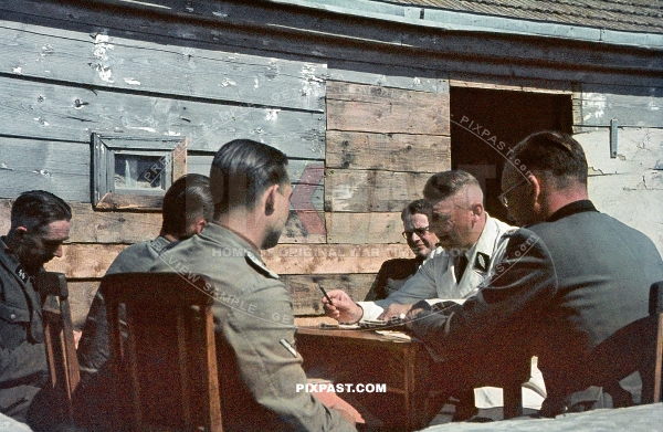 Special German officers have strategy meeting beside wooden hut. Ukraine 1943
