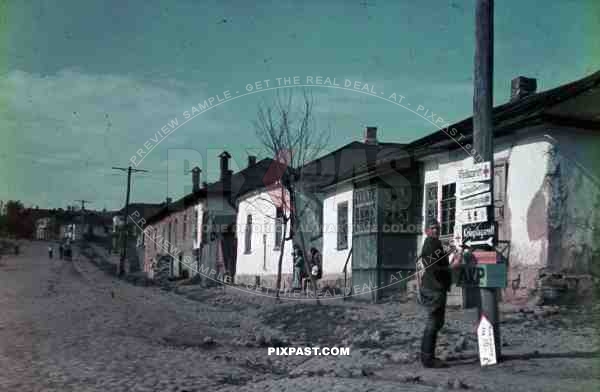 WW2 Color German soldier painting military road signs in village Ukraine 1942
