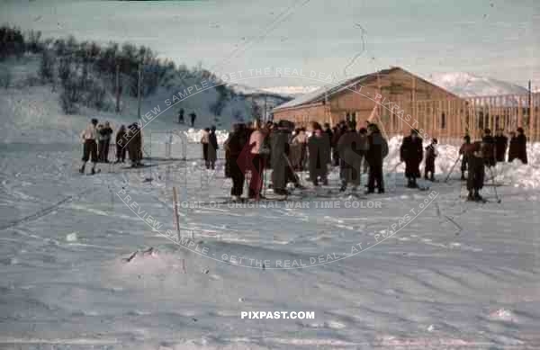 WW2 Color Norway 1940 Norwegian Civilians snow skiing beside german military barracks building site