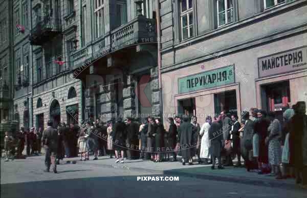 WW2 Color Poor peasents waiting for documents from german government office in town Ukraine hand made red flags 1942