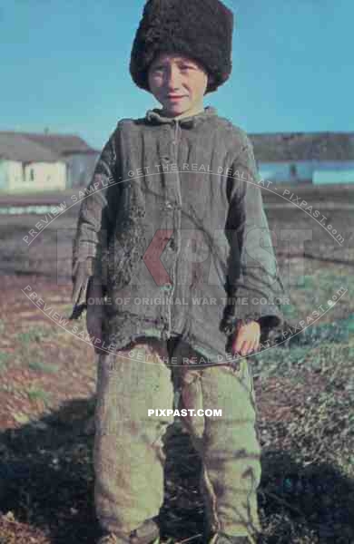 Young Russian farmer boy wearing traditional hat in Village. photographed by German war reporter. Russia 1943.