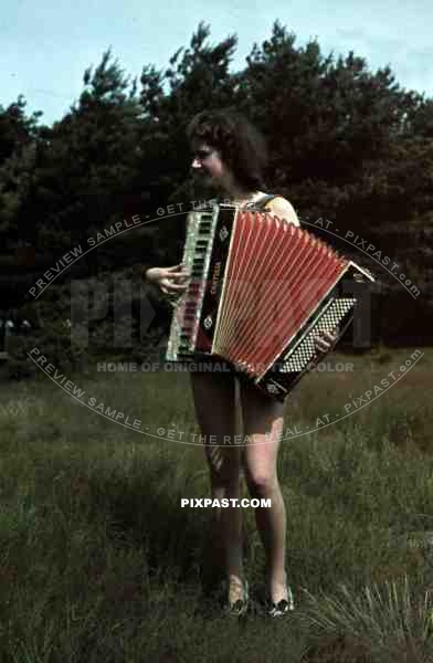 young woman in Berlin Park 1940 plays cantulia accordion, music