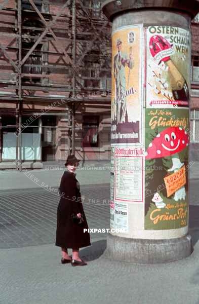 Young women reading posters on a Advertising column. Litfasssaule. for the Halle Saale Theatre ( Saxony-Anhalt ) 1940