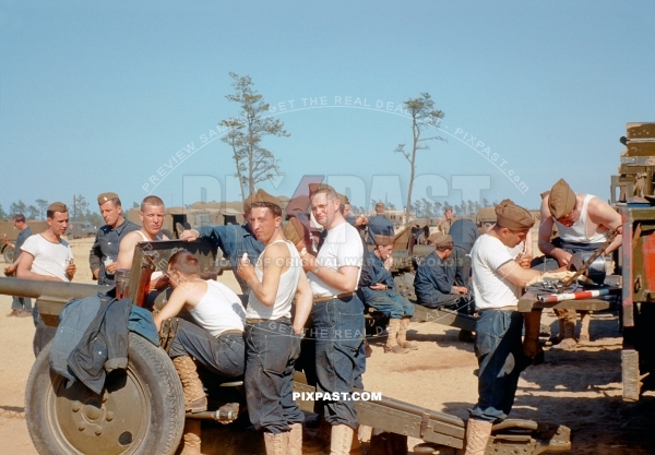 American army artillery unit cleaning the breach of a Howitzer artillery cannon. California 1942. Soldiers in jeans trousers.