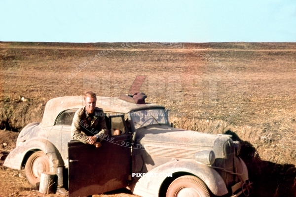 Army driver in his 1938 Opel Super 6 Cabriolet staff car in a Russian field near Stalingrad 1941. 297 Infantry Division