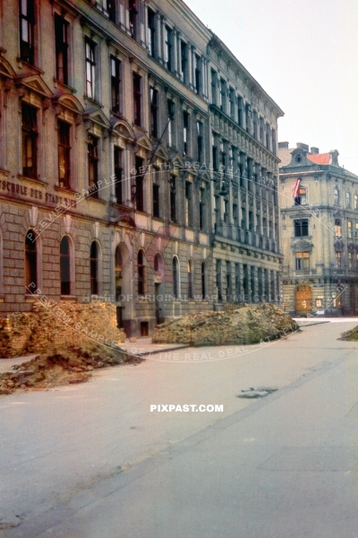 Battle damaged Vienna Austria May 1945. Local School badly damaged with piles of pricks on the road. Austrian flag.