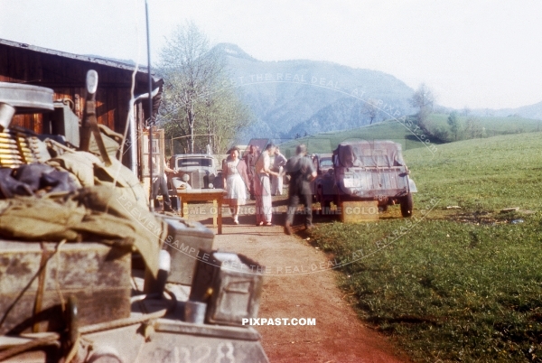 German Volkswagen Kubelwagen in late war camouflage parked beside American Greyhound armored Car. Murnau 1945