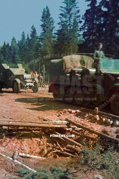 Germany army half track tractor pulling captured Russian armored car out of forest. Russia 1942