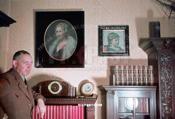 Mein Zimmer bunt 1939. Father of German sailor showing proudly his sitting room. Leather chair, paintings, wall carpet.