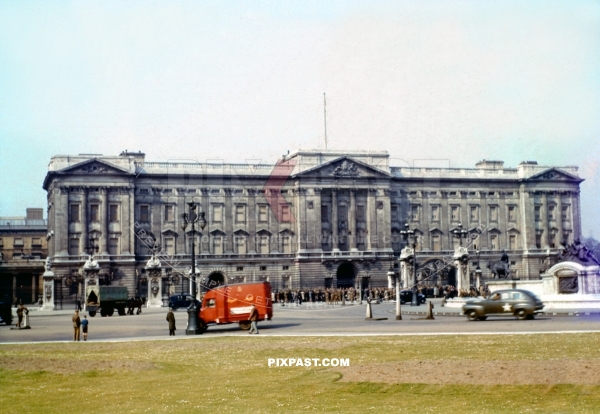 Royal Mail truck and American army staff car passing Buckingham Palace. London England 1944. Windows covered