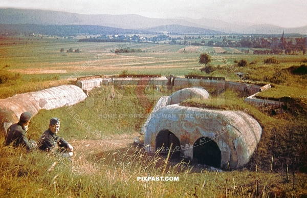 Two German soldiers looking at a French army bunker concrete fort. Part of the Maginot line France 1940