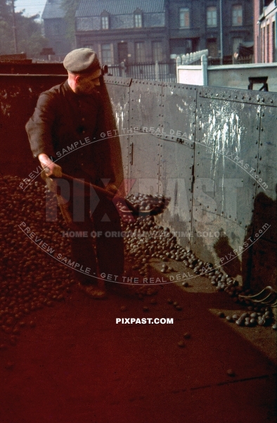 World War One German veteran with WW1 cap shoveling coal out of train in NRW Dortmund Germany 1941