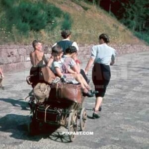 A German displaced family moving their last possessions with a wooden wagon. Mother and daughter pull. Silesia 1945
