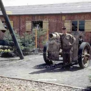 American GI soldier standing beside captured German 15 cm sIG 33 Howitzer. Army barracks. Homburg Germany 1945