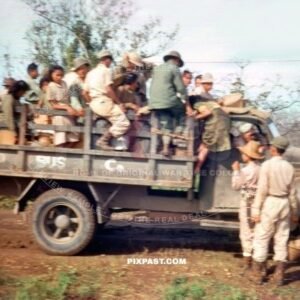 American soldiers with Philippine refugees being transported by captured Japanese army truck. New Guinea 1944