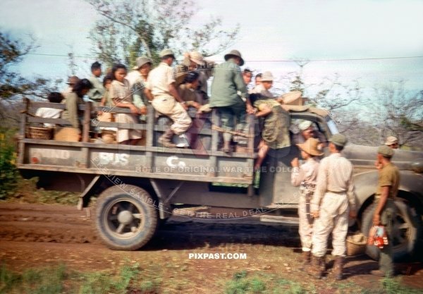 American soldiers with Philippine refugees being transported by captured Japanese army truck. New Guinea 1944
