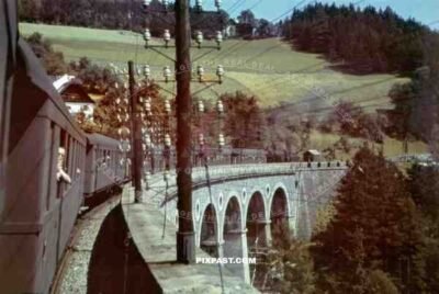 An Austrian Steam Lokomotive pulling passengers through the mountains near Burgkirchen Austria 1939
