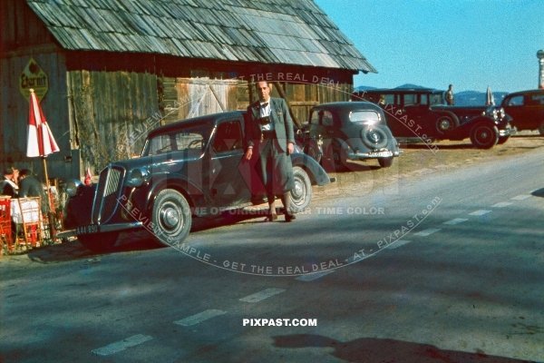 Austrian daddy beside his vintage Renault Celtaquatre family car beside Austrian beer garden. Austria 1938.