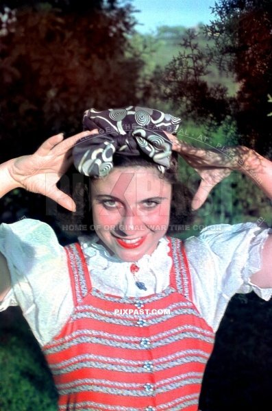 Beautiful young french women smiling in red dress and hair bow. Orleans France June 1940