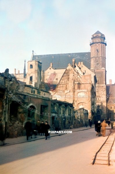 Bombed houses and shops on Burg Strasse in Leipzig 1945. Showing the Thomaskirche in background. Train tracks.