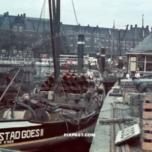 Cargo Steam Barge stad Goes II loaded with steel pipes and beer in front of Amsterdam Centraal station Netherlands 1940