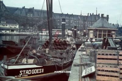Cargo Steam Barge stad Goes II loaded with steel pipes and beer in front of Amsterdam Centraal station Netherlands 1940