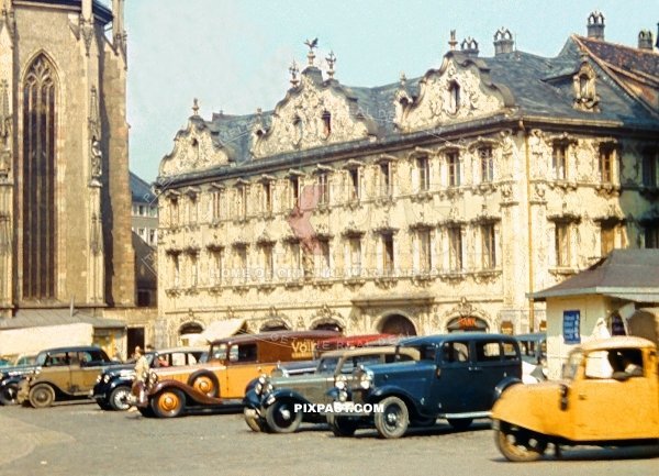 Cars and vans parked on Oberer Markt in front of Das Haus zum Falken Das Haus zum Falken and Marienkapelle Wurzburg 1938
