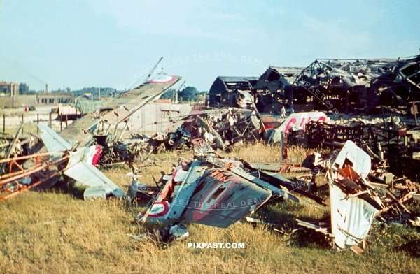 Destroyed French air force fighter planes on landing strip in front of plane hanger. France 1940. Battle of France.