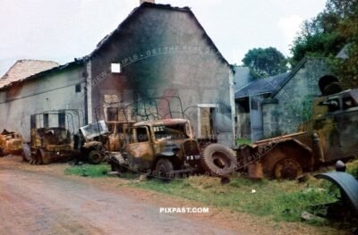 Destroyed French armored car Panhard 178 CDM with a 25 mm gun with army trucks and lorries. road to Dunkirk France 1940