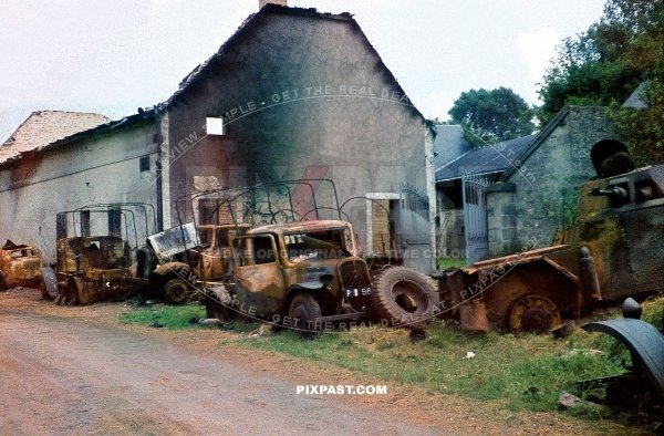 Destroyed French armored car Panhard 178 CDM with a 25 mm gun with army trucks and lorries. road to Dunkirk France 1940
