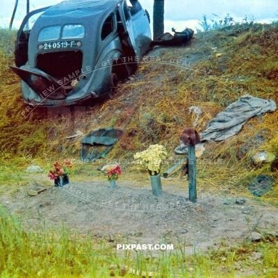 Destroyed french army staff car on road sign. French soldier burial grave in ditch. France near Dunkirk 1940