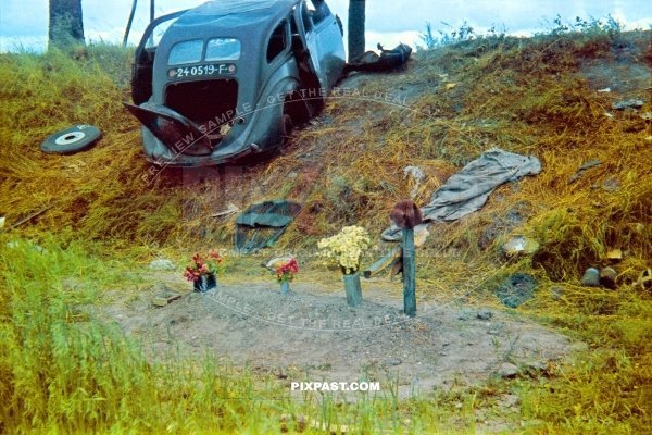 Destroyed french army staff car on road sign. French soldier burial grave in ditch. France near Dunkirk 1940
