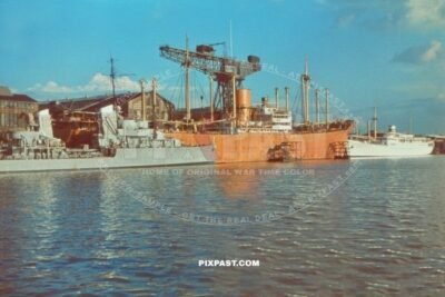 German Kriegsmarine navy red construction building ship parked beside navy cruiser. Kiel Germany 1939