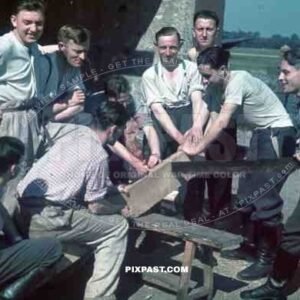 German Luftwaffe Ground crew build staff quarters using large wood saw beside air base landing strip, summer 1941.