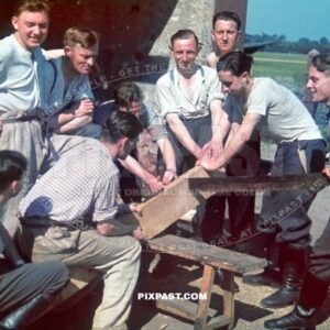 German Luftwaffe air force soldiers cutting wood with long timber saw. Bomber plane Air field. France 1940