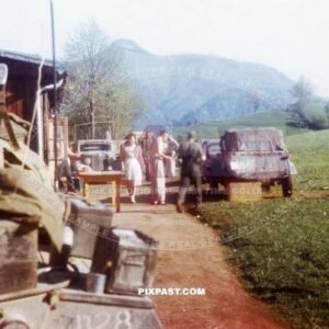 German Volkswagen Kubelwagen in late war camouflage parked beside American Greyhound armored Car. Murnau 1945