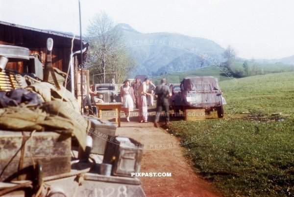 German Volkswagen Kubelwagen in late war camouflage parked beside American Greyhound armored Car. Murnau 1945