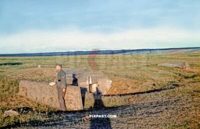 German Wehrmacht Gefreiter inspecting small infantry machine-gun bunker in Netherlands field 1940
