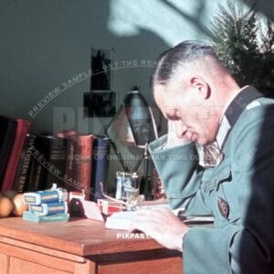 German army officer reading book. Rolls of German agfacolor film sitting on his table. Munich Germany 1942