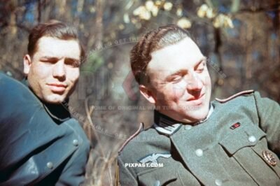 German artillery officer resting with Kradmelder Motorbike Messenger in rubber rain jacket.Russia 1942. 8th Panzer Division