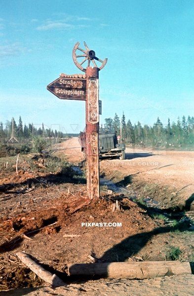 German half track passing road sign post. Strasse der Gebirgsjager North Finnland 1942. Narvik Shield