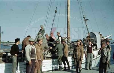 German mountain troops Gebirgsjager loading supplies onto small Greek fishing boat. Greek soldiers Greece 1942